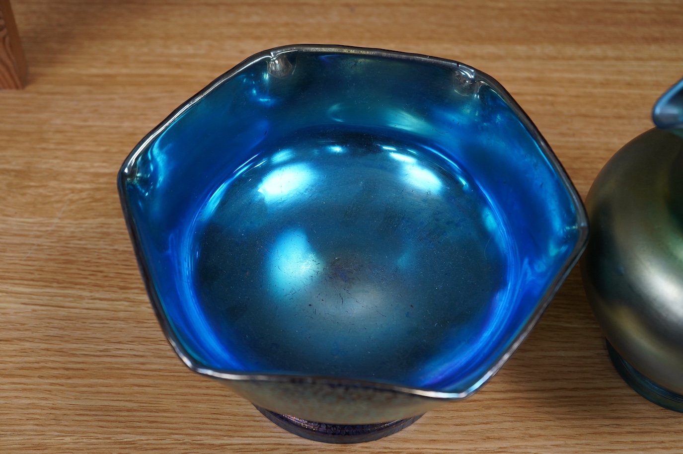 A Loetz cobalt Papillon iridescent glass footed hexagonal bowl, a Kralik blue iridescent vase and a large Bohemian iridescent glass jug (3) tallest 21cm. Condition - good